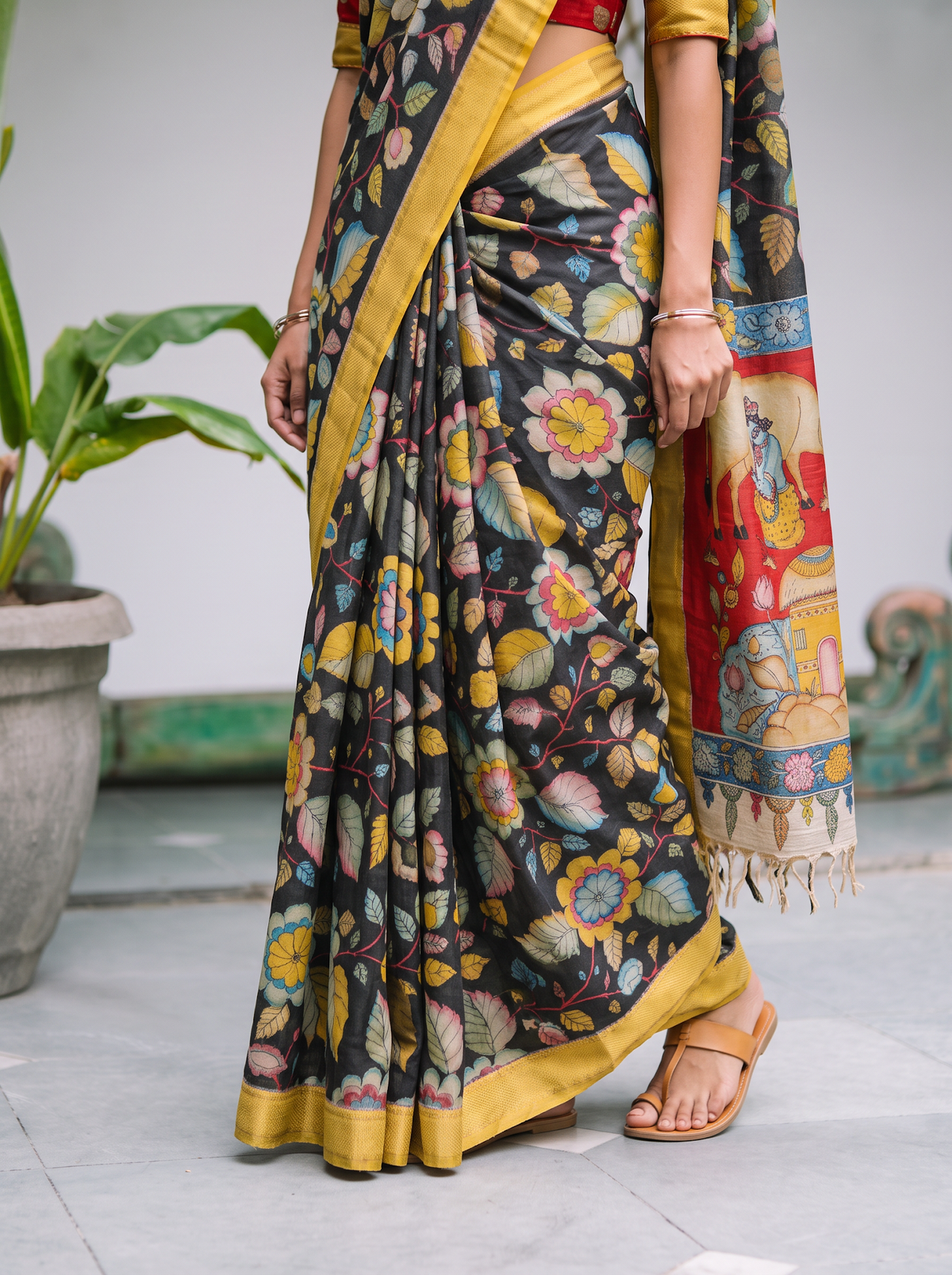 Pleats of the black body with pastel flowers above a mustard yellow hem, AI visual of the saree, iTokri