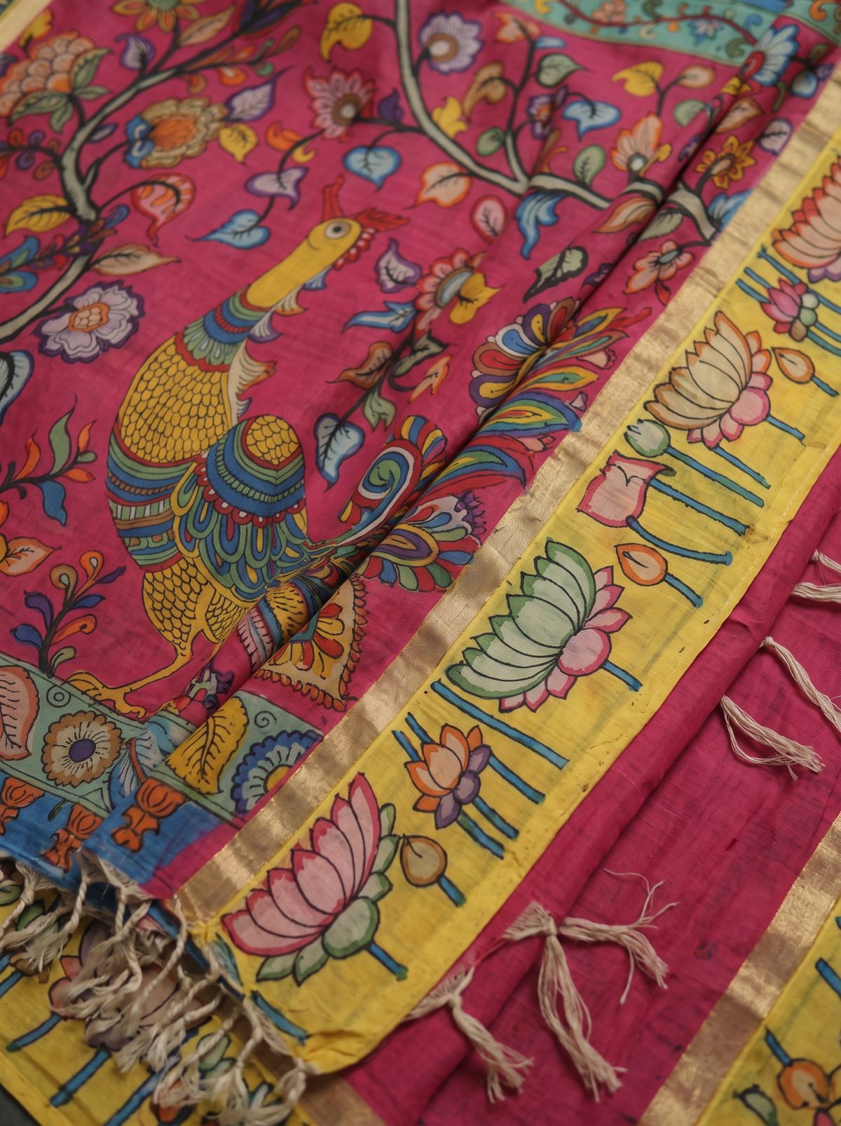 Detail of the peacock on the magenta pallu beside the yellow lotus row and tassels, AI visual of the saree, iTokri