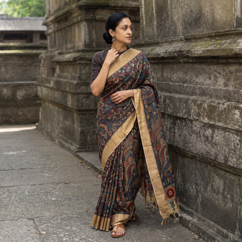 Brown Pure Handloom Desi Tussar Silk Handpainted Srikalahasti Pen Kalamkari Saree with Zari Border, draped and worn by a woman, AI visual of the saree, iTokri