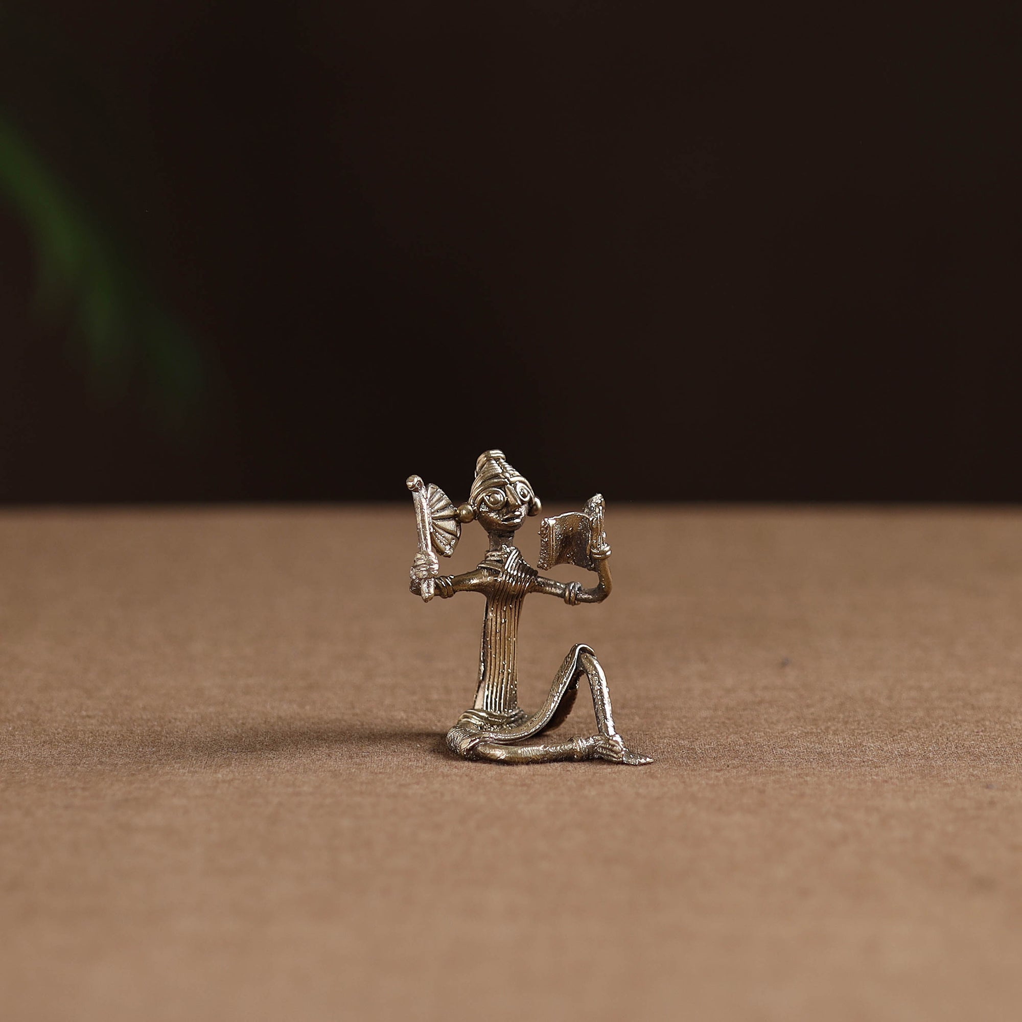 Sitting lady with reading book tribal odisha dokra art