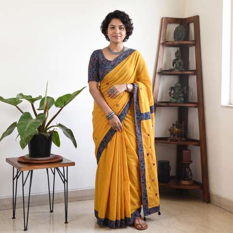 Yellow Tagai & Mirror Embroidered Ajrakh Patchwork Pure Mul Cotton Saree with Blouse Piece, draped and worn by a woman, AI visual of the saree, iTokri