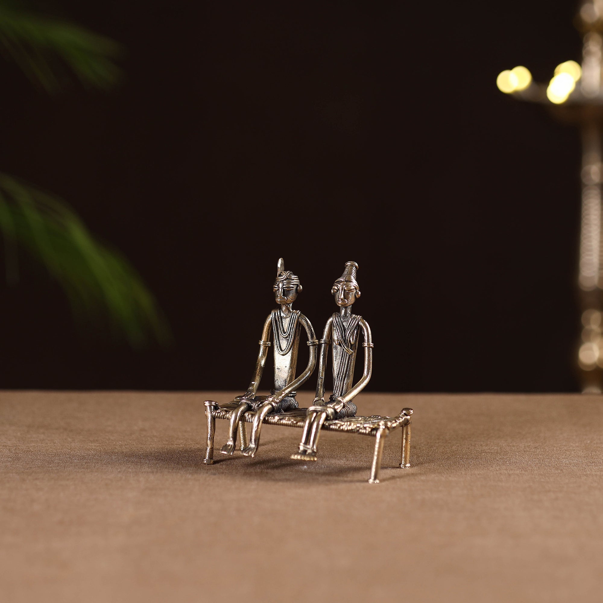 Couple sitting on cot - tribal odisha dokra handmade home