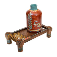 Rustic Red Madhubani Vase placed on Ethnic Charpai Stand