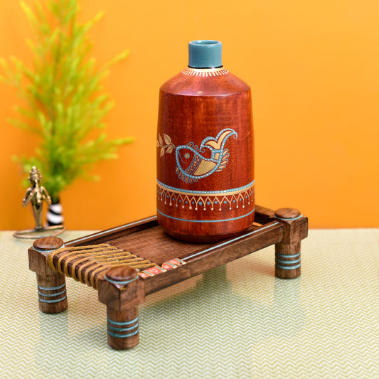 Rustic Red Madhubani Vase placed on Ethnic Charpai Stand
